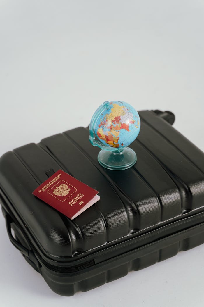 A passport, luggage, and mini globe symbolize travel planning and wanderlust.